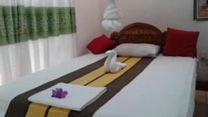 Un dormitorio con una cama con un cisne. en Kalana Homestay, en Sigiriya