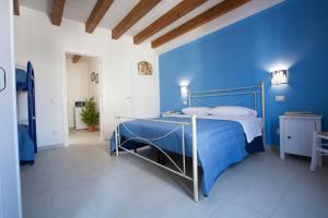 a blue bedroom with a bed with a metal frame at CASA Annmarie in Castellammare del Golfo