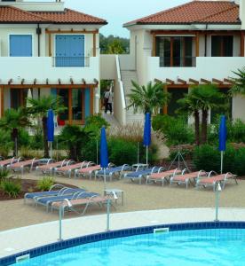 un complejo con piscina y tumbonas en Villaggio A Mare, en Caorle