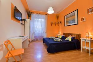ローマにあるRome Vatican B&Bのオレンジ色の壁のベッドルーム1室、ベッド1台、デスクが備わります。
