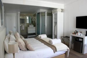 a bedroom with two beds and a television in it at Swakopmund Luxury Suites in Swakopmund