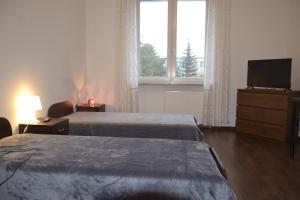 a hotel room with two beds and a television at Warszawa Stare Bielany in Warsaw