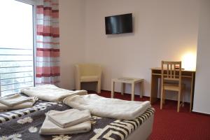 a room with a bed and a table and a television at Warszawa Stare Bielany in Warsaw