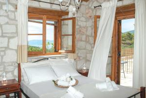 ヴァシリコスにあるAloniのベッドルーム1室(窓、白いベッド1台付)
