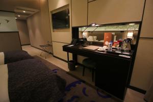 una camera d'albergo con scrivania e specchio di Waxwing Hotel a Hatay