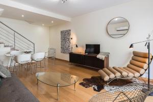 a living room with a couch and a table and a mirror at Flea Market Alfama House (Patio/Pool/AC/Garage) in Lisbon
