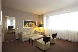 a living room with a couch and chairs and a window at H4 Hotel Berlin Alexanderplatz in Berlin