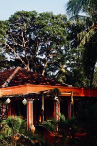 a house with a red roof with trees in the background at Allens home stay in Jaffna +17 photos
