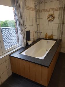 y baño con bañera y ventana. en Widdingenhof, en Wellen
