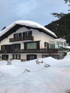 ein Haus mit Schnee auf dem Boden davor in der Unterkunft "Falkenstein" in Davos