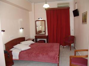 a bedroom with a bed and a mirror and a red curtain at Hotel Cosmos in Athens