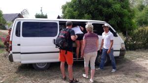 
people standing around a white van at Grandview Cottages Resort in Siaton
