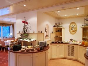 a kitchen with a table with food on it at Hotel-Garni Drachenburg in Mittenwald