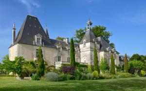 a large white house with a black roof at Chateau Le Mas de Montet in Petit-Bersac