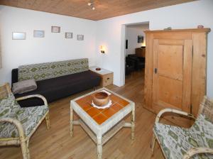 een woonkamer met een bank en een tafel en stoelen bij Haus Pyrola in Davos
