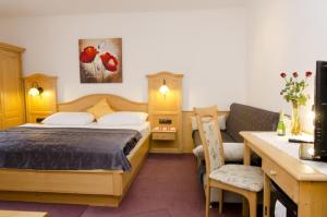 a bedroom with a bed and a desk with a computer at Pension Parzer Pressbaum bei Wien in Pressbaum