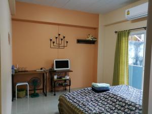 a bedroom with a bed and a desk with a computer at T.M. Home, Hatyai in Hat Yai