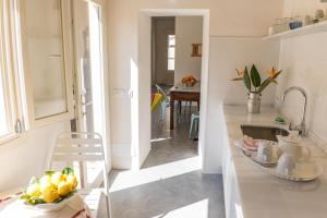 a kitchen with a sink and a bowl of fruit on a table at Blue Casita ETV 7845 in Pollença