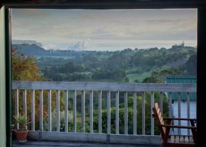 a chair sitting on a porch looking out at a valley at The Grange Lodge in Napier
