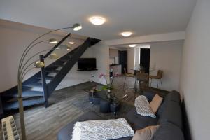 a living room with a couch and a staircase at Gîtes Au Château Fleuri in Eguisheim