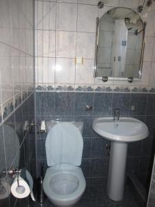 a bathroom with a white toilet and a sink at Guesthouse Olimp in Sozopol
