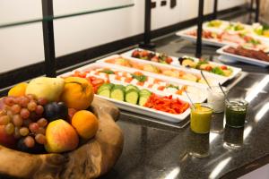ein Buffet mit einer Schüssel Obst und Tellern mit Essen in der Unterkunft Hotel Motodrom in Hockenheim + 11 Fotos