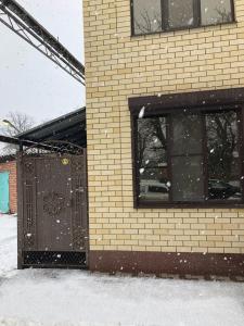 エイスクにあるGuest House na Karla Libknekhta 68の雪中の窓とドアが2つある建物