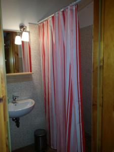 a bathroom with a red and white shower curtain and a sink at R&B Albero Cavo Parma in Parma