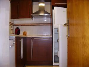 a kitchen with brown cabinets and a refrigerator at Cal Duran in Bellver de Cerdanya