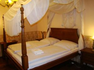 a bedroom with a canopy bed with two white pillows at Zámecké ubytování U dobré hraběnky in Kunín