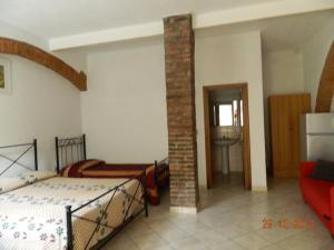 1 dormitorio con 2 camas y un pilar de ladrillo en Podere Santo Signoretto, en San Vincenzo