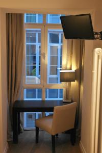 a desk and a chair in front of a window at Hotel Cuéntame La Puebla in Burgos