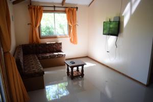 a living room with a couch and a tv at Cabañas Kumelka in Villarrica