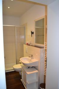 ein Badezimmer mit einem Waschbecken, einem WC und einem Spiegel in der Unterkunft Ferienwohnung Holland 5a in Lügde