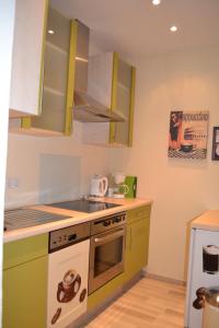 uma cozinha com armários verdes e um fogão forno superior em Ferienwohnung Holland 5a em Lügde