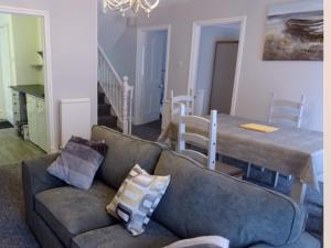a living room with a couch and a table at Beechwood House in New Quay