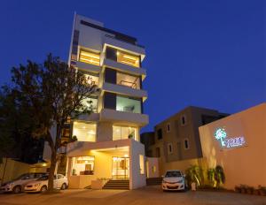 ein hohes Gebäude mit davor geparkt in der Unterkunft Hotel K Tree - A Boutique Hotel in Kolhapur