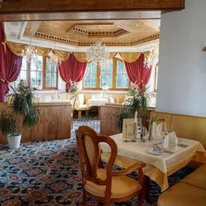 a dining room with a table and a couch at Wellnesshotel Parkschlössl zu Thyrnau " Adults only" in Thyrnau