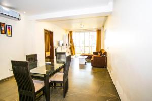 a dining room and living room with a table and chairs at Eternal wave by HappyInch in Calangute
