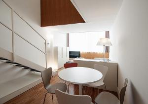 a dining room with a white table and chairs at BB Hotels Aparthotel Desuite in Milan