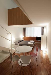 Pokój ze stołem, krzesłami i łóżkiem w obiekcie BB Hotels Aparthotel Desuite w Mediolanie