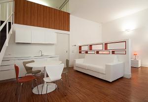 a living room with a white couch and a table at BB Hotels Aparthotel Desuite in Milan