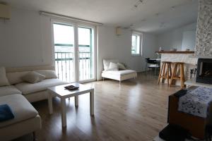 ein Wohnzimmer mit einem Sofa und einem Tisch in der Unterkunft Apartments Marko Rava in Rava