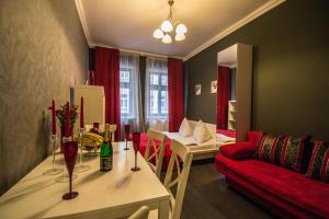 プラハにあるRuterra Apartment Cimburkovaの小さなリビングルーム(赤いソファ、テーブル付)