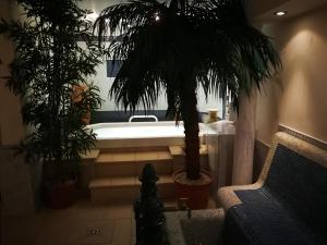 a bathroom with a bath tub and two palm trees at Hotel Kärntnerhof & SeeBlick Suiten in Lake Pressegg