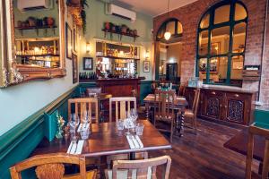 a restaurant with wooden tables and chairs and a bar at The Old Coffee Tavern in Warwick