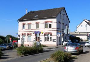 a pink and white building with cars parked in front of it at Millrather Brauhaus in Erkrath