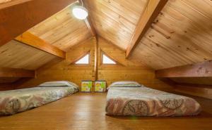 um quarto no sótão com 2 camas e tectos em madeira em El Mas de Xetà em Luchente
