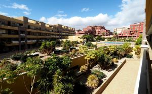 an apartment complex with a courtyard with palm trees at La Perla: Sea View and Pool (family apartment) in El Médano
