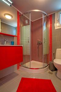 e bagno con doccia, servizi igienici e piastrelle rosse. di Elegant 1BR by Heraklion Beach Sun &Comfort Await ad Amoudara Herakliou
